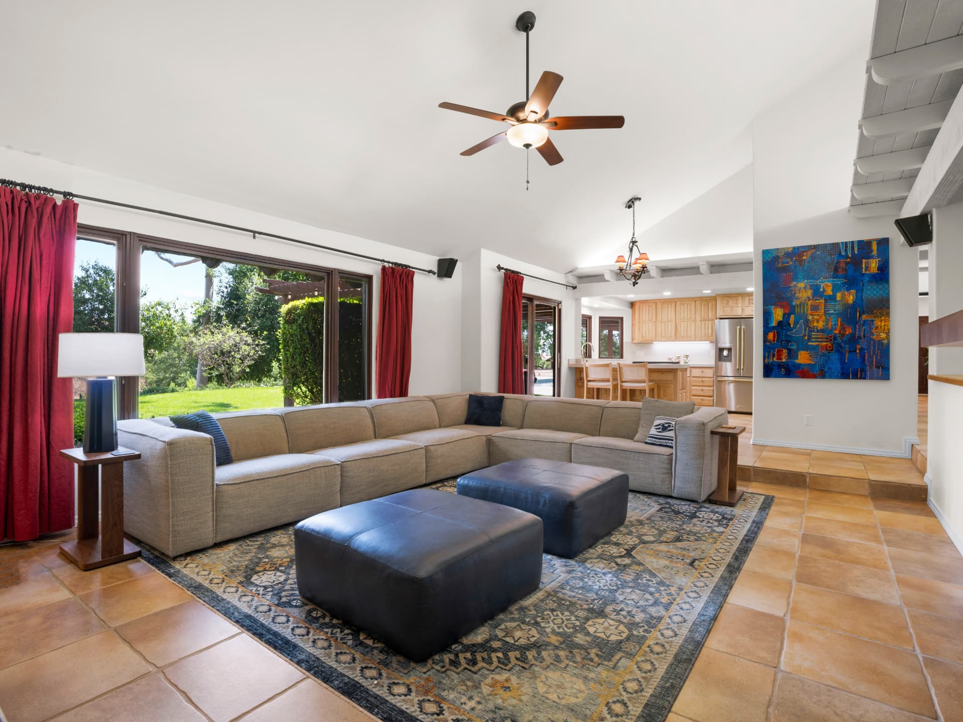 Open living room with sectional sofa opening to the kitchen and rear yard